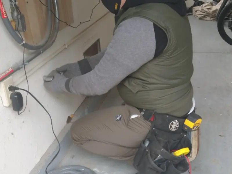 Electrician performing outlet wiring in a Wilton garage